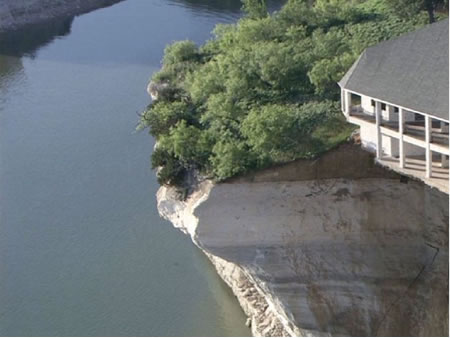 view of cliff and falling debris and water level